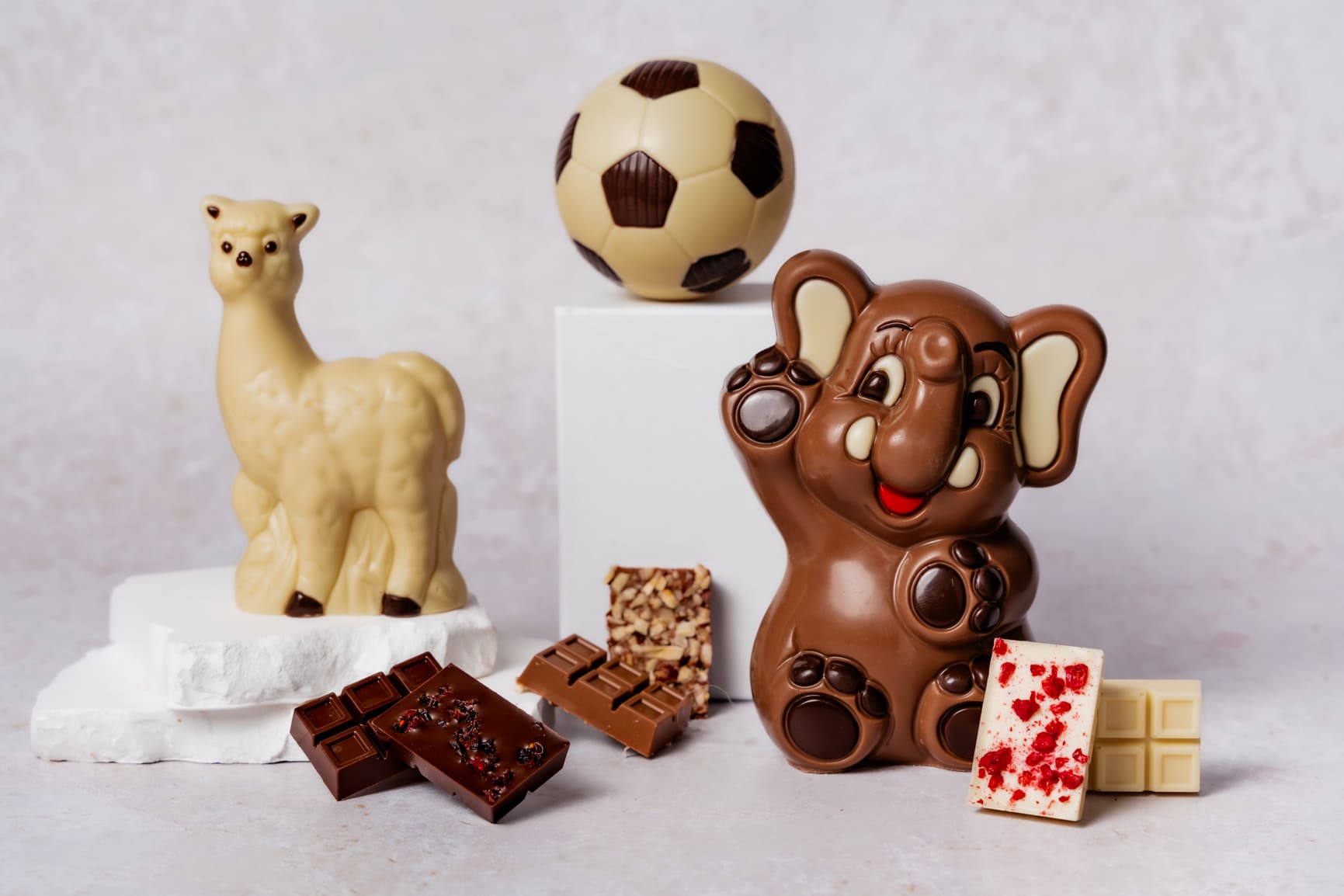 Schokoladenfigur in Form eines Elefant, eines Lamas und eines Fußballes, dekoriert mit Schokladetafeln