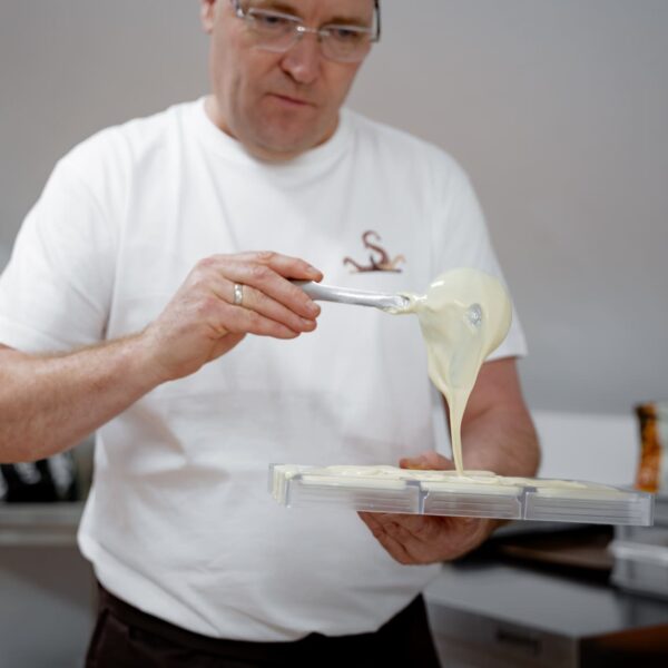 Johann Mascherbauer schüttet weiße Schokolade in eine Form.