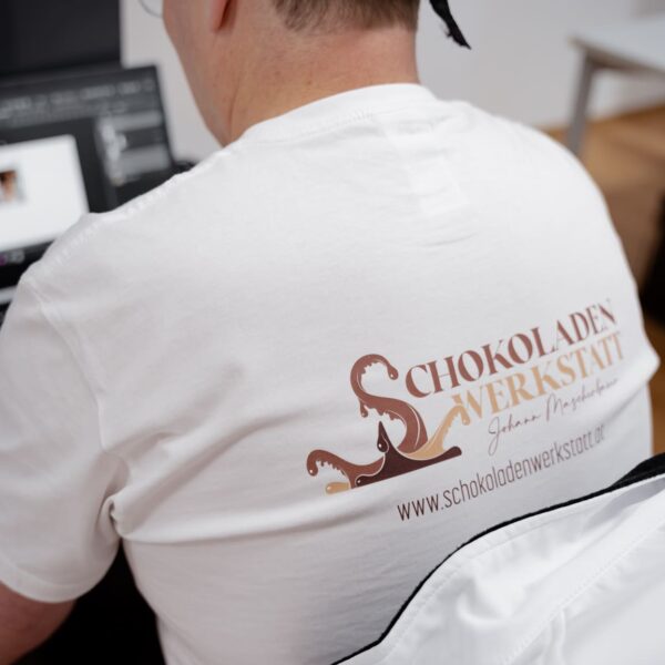 Nahaufnahme des Rückens von Johann Mascherbauer mit Logo der Schokoladenwerkstatt
