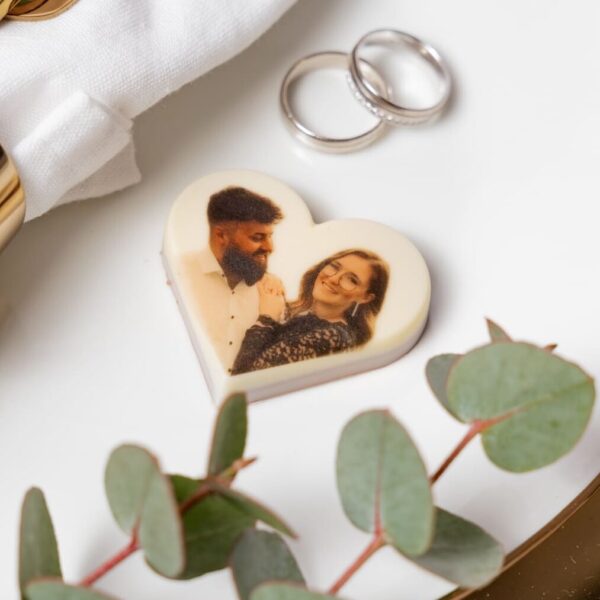 Festlich eingedeckter Tisch mit goldenen Serviettenringen, Besteck und Schokoladenherz