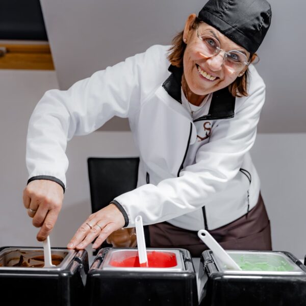 Barbara Mascherbauer schaut in die Kamera und rührt im Schokoladen-Topf